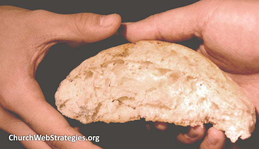 close-up of hands exchanging a piece of bread