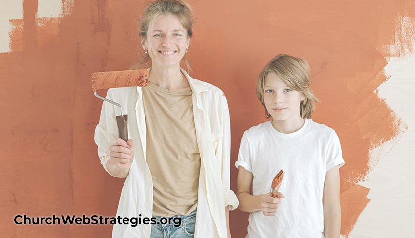 Mother and son holding paint roller & brushes