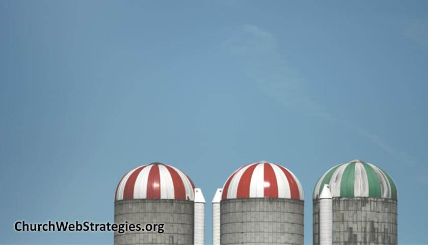 the tops of grain silos against a blue sky