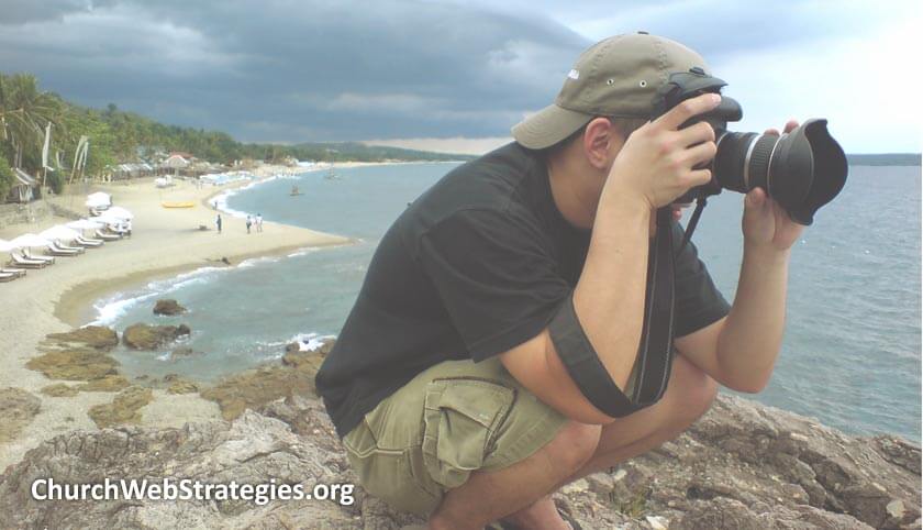 man on coastal cliff taking a photograph