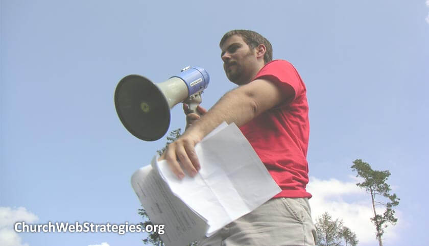 man outside holding papers and a megaphone