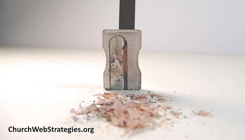 pencil in sharpener with shavings on a table