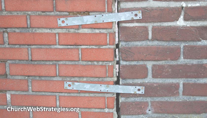 two brick walls held together with metal bars