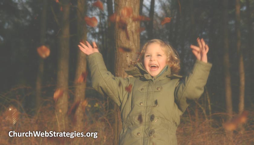 laughing child throwing leaves in air