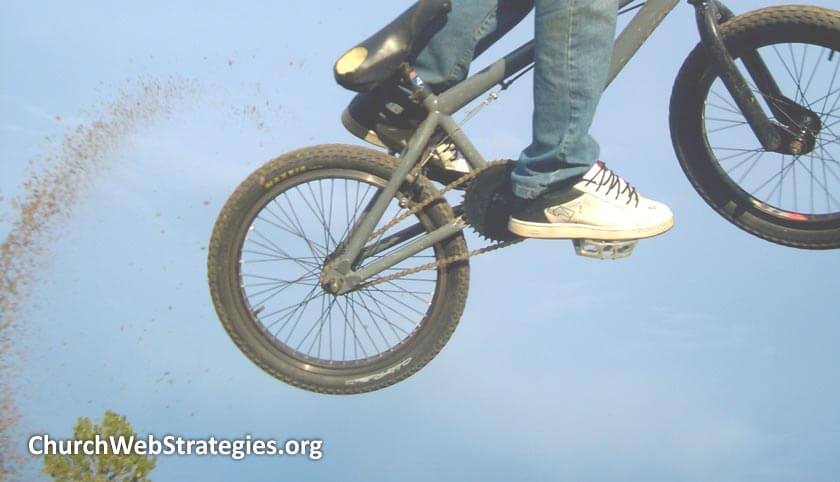 boy riding bicycle off a jump