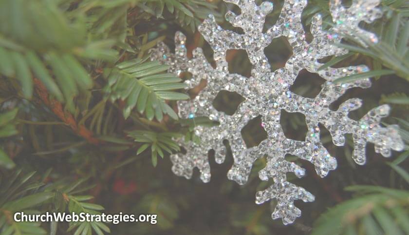 plastic snowflake hanging on pine tree